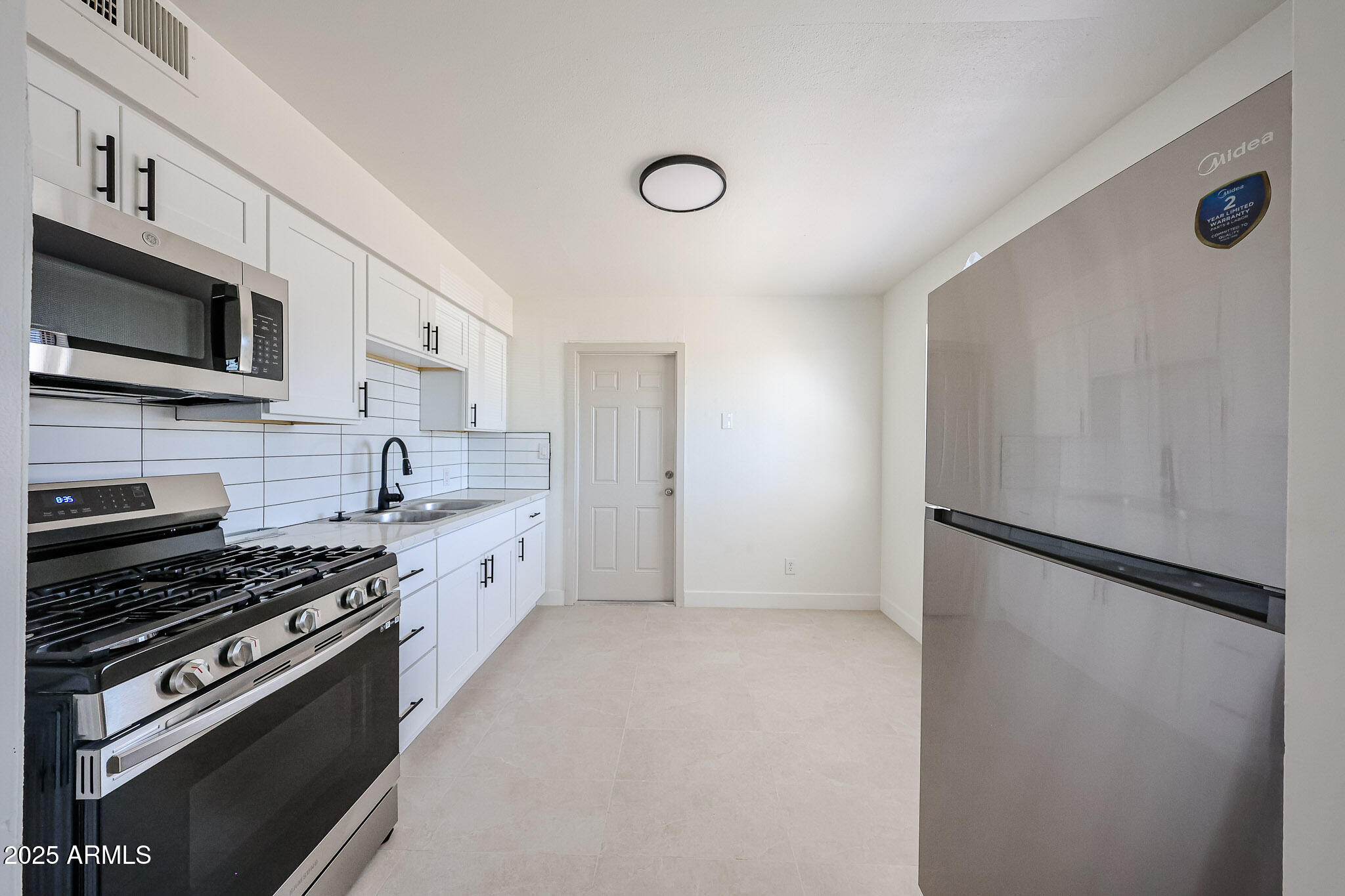 10202 North 15th Avenue, Unit 2 Phoenix, AZ 85021 - Photo 9 of 34 a kitchen with stainless steel appliances a refrigerator stove and microwave