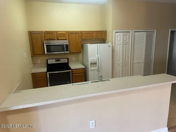 a kitchen with stainless steel appliances a refrigerator and a stove top oven