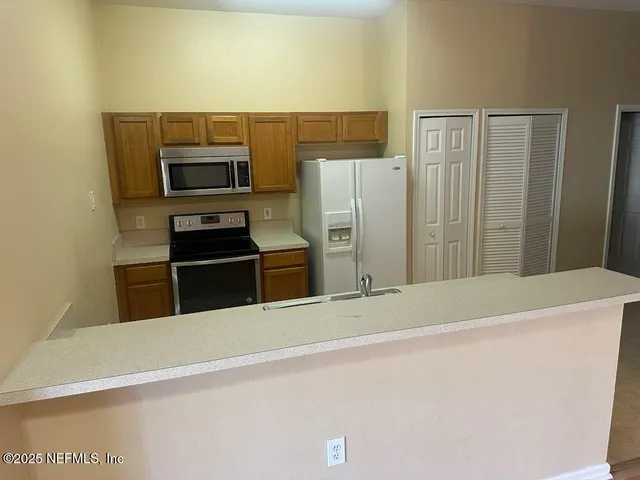 a kitchen with stainless steel appliances a refrigerator and a stove top oven