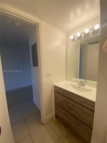 a bathroom with a granite countertop sink a mirror and a shower