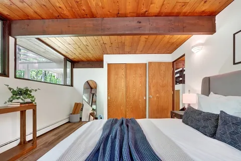 a bedroom with a bed and wooden floor