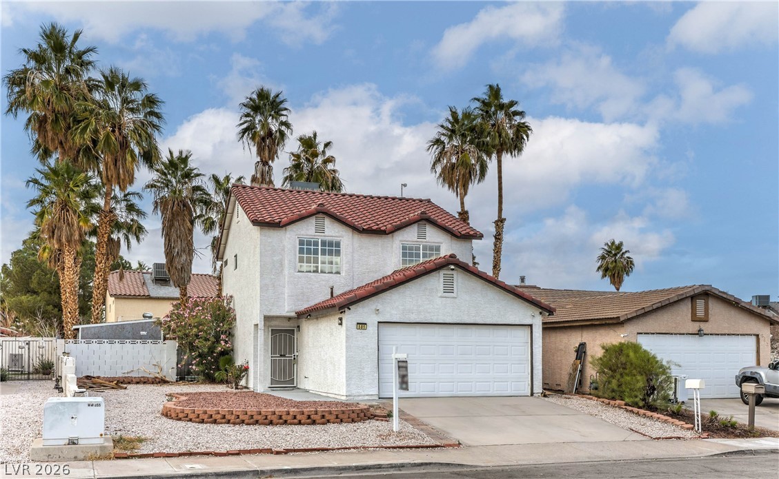 581 Carleton Drive Henderson, NV 89014 - Photo 2 of 37 White stucco home with a terracotta roof, a two-car garage, and desert-friendly landscaping.
