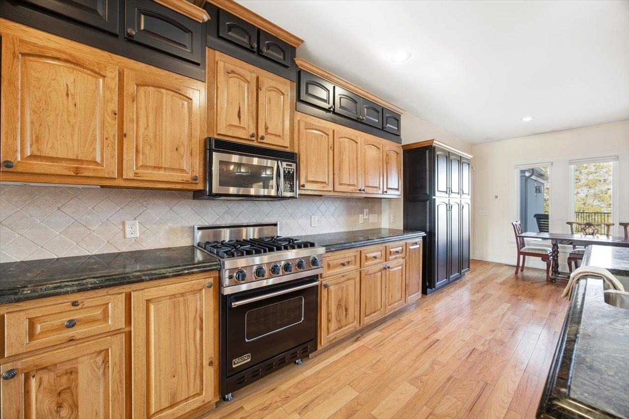 2223 Airport Road Bridgewater, VA 22812 - Photo 11 of 74 a kitchen with stainless steel appliances granite countertop a stove top oven a sink dishwasher a dining table and chairs with wooden floor