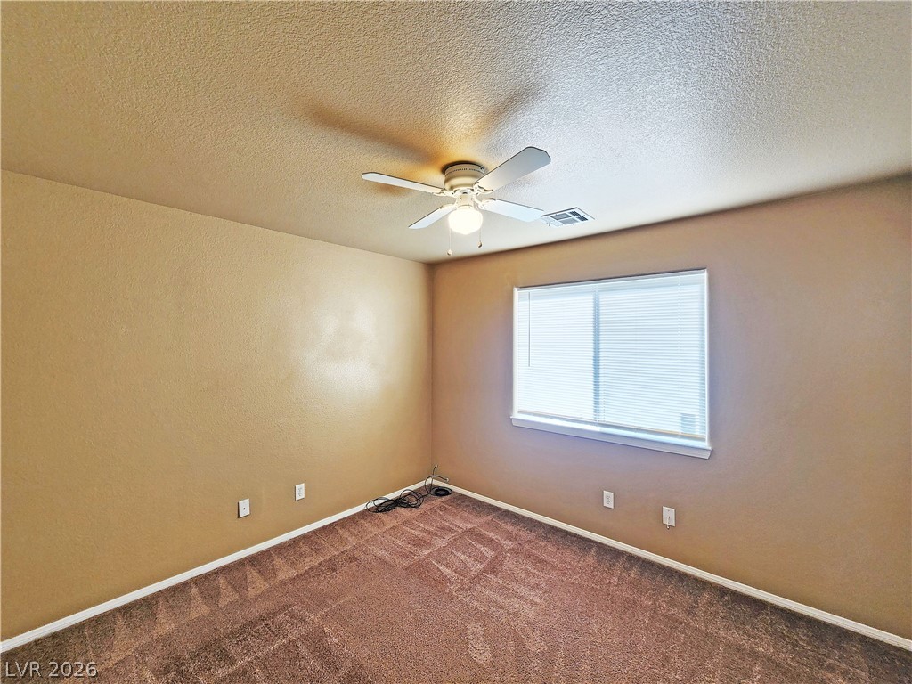 3680 Ravine Avenue Pahrump, NV 89048 - Photo 23 of 28 Empty room with carpet flooring, visible vents, a ceiling fan, and baseboards