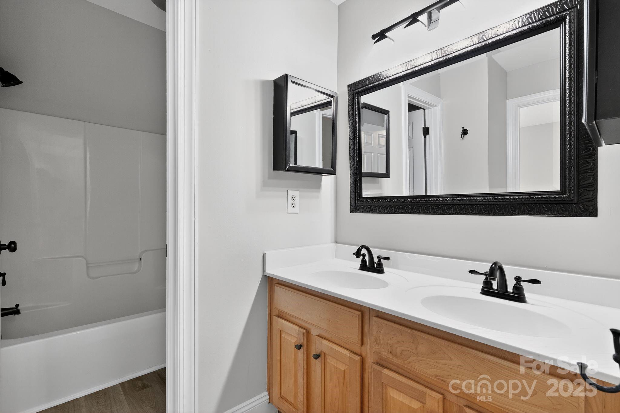 1000 Potters Bluff Road Monroe, NC 28110 - Photo 15 of 20 a bathroom with a double vanity sink mirror and bathtub