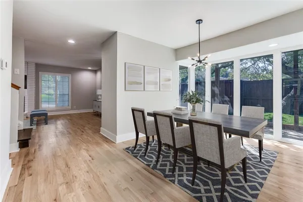 a dining room with furniture wooden floor a chandelier and a rug