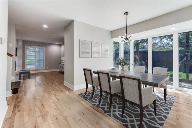 a dining room with furniture wooden floor a chandelier and a rug