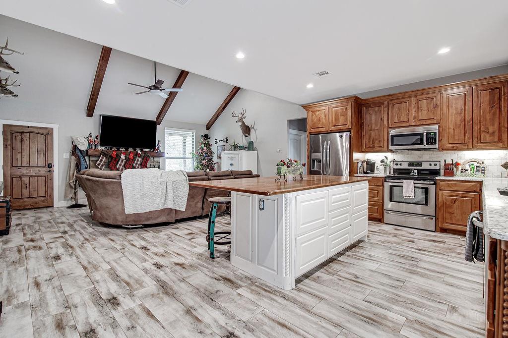 3817 Cross Timber Road Burleson, TX 76028 - Photo 17 of 36 a kitchen with kitchen island a sink cabinets and wooden floor