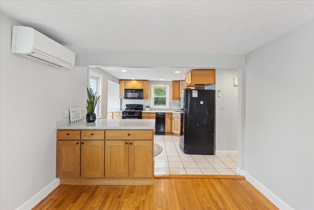 7 G Street Hull, MA 02045 - Photo 9 of 34 a living room with stainless steel appliances kitchen island granite countertop a refrigerator a stove a sink and dishwasher with wooden floor