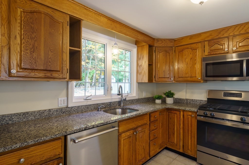 90 Hartwick Street Springfield, MA 01108 - Photo 9 of 33 a kitchen with stainless steel appliances granite countertop a sink a microwave cabinets and a window
