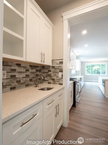 a view of a kitchen counter space a stove wooden floor cabinets
