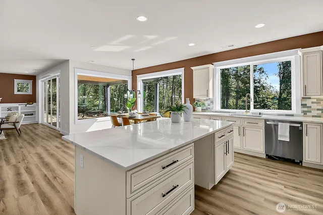 a kitchen with stainless steel appliances granite countertop a stove and a large window