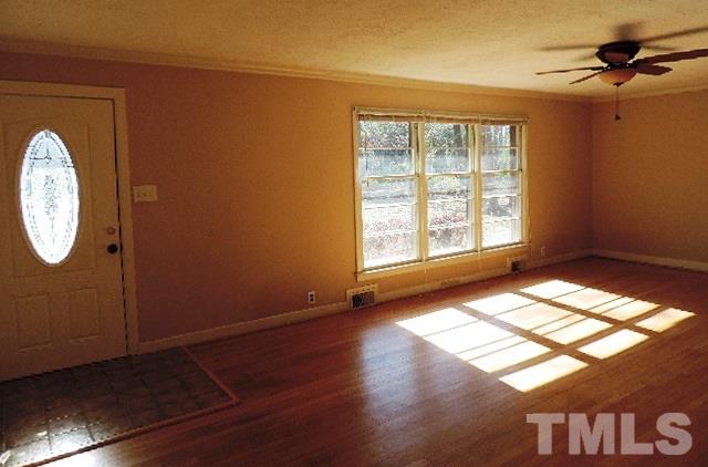 3005 Hickory Road Raleigh, NC 27616 - Photo 3 of 25 a view of an empty room with a window and wooden floor