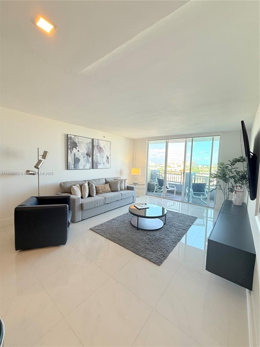 90 Alton Road, Unit 909 Miami Beach, FL 33139 - Photo 14 of 37 a living room with furniture and a flat screen tv