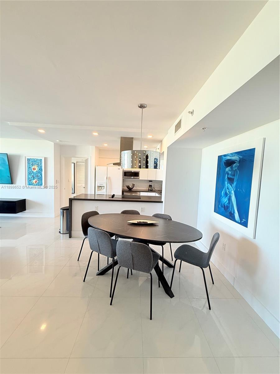90 Alton Road, Unit 909 Miami Beach, FL 33139 - Photo 16 of 37 a view of a dining room with furniture