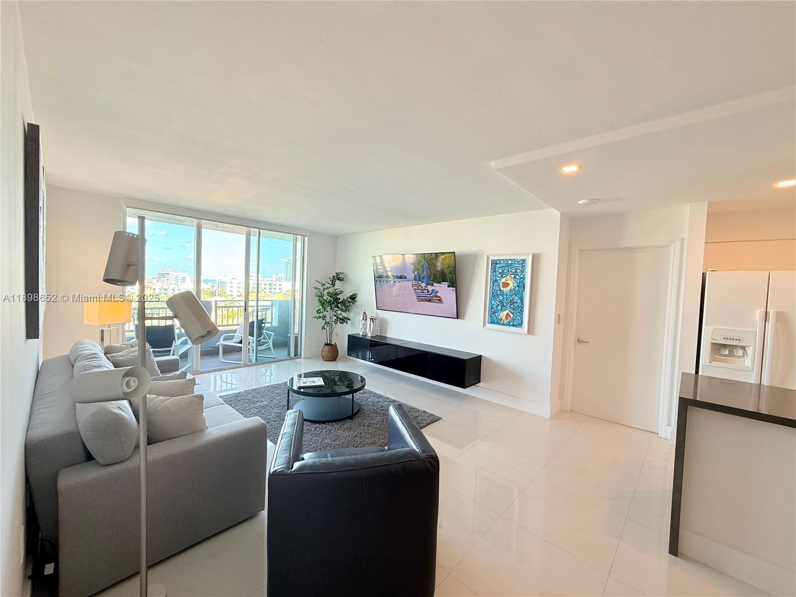 90 Alton Road, Unit 909 Miami Beach, FL 33139 - Photo 17 of 37 a living room with furniture and a flat screen tv