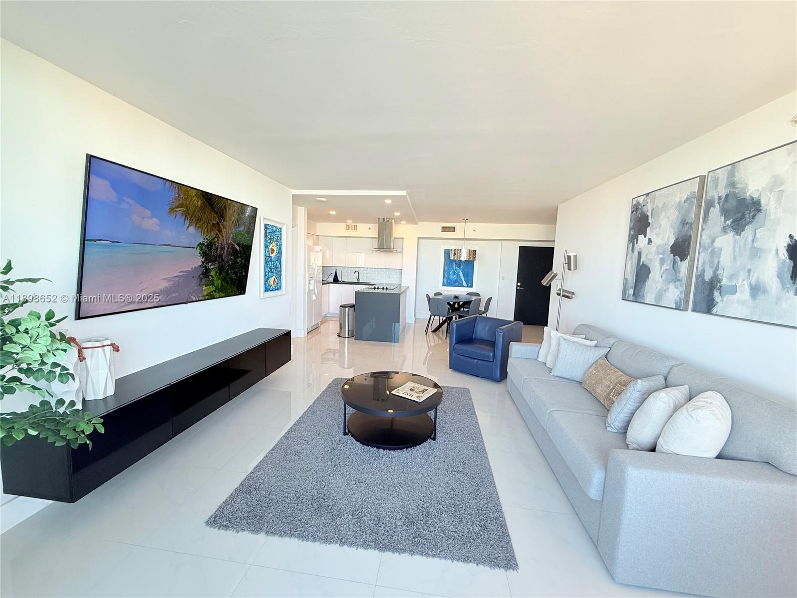 90 Alton Road, Unit 909 Miami Beach, FL 33139 - Photo 19 of 37 a living room with furniture and a flat screen tv