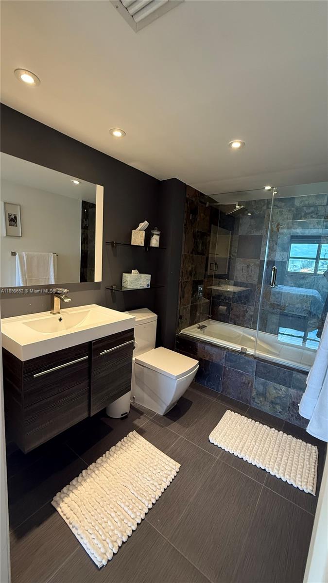 90 Alton Road, Unit 909 Miami Beach, FL 33139 - Photo 2 of 37 a bathroom with a double vanity sink and a bathtub
