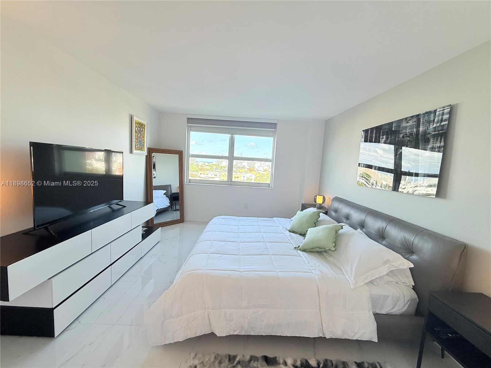 90 Alton Road, Unit 909 Miami Beach, FL 33139 - Photo 27 of 37 a bedroom with a bed and a flat screen tv