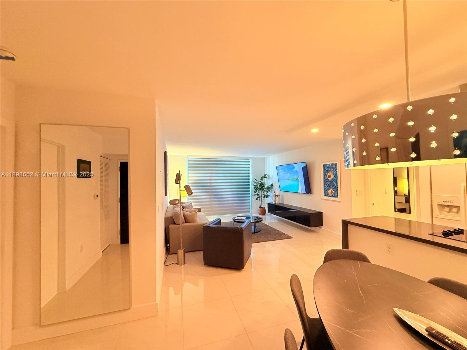 90 Alton Road, Unit 909 Miami Beach, FL 33139 - Photo 34 of 37 a living room with furniture and a flat screen tv