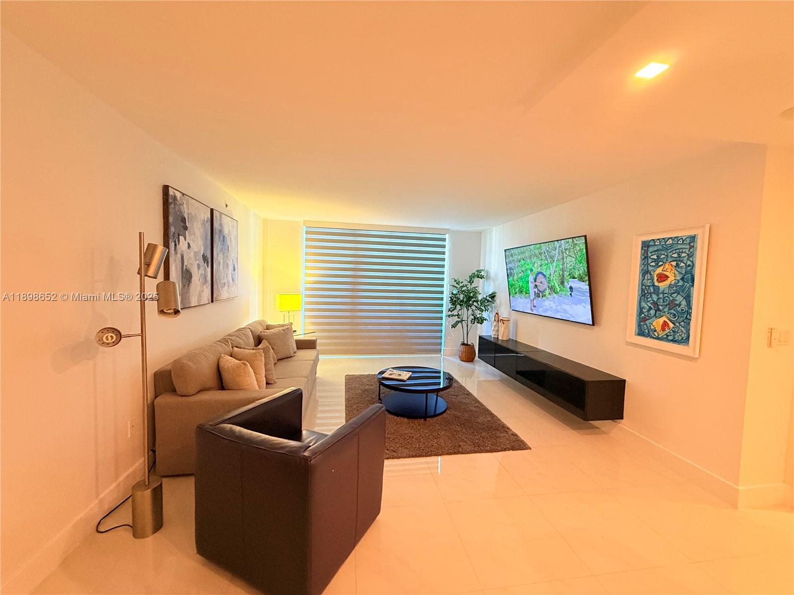 90 Alton Road, Unit 909 Miami Beach, FL 33139 - Photo 35 of 37 a living room with furniture and a window