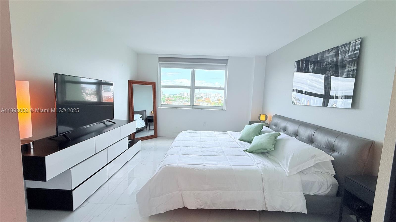 90 Alton Road, Unit 909 Miami Beach, FL 33139 - Photo 4 of 37 a bedroom with a bed and a flat screen tv