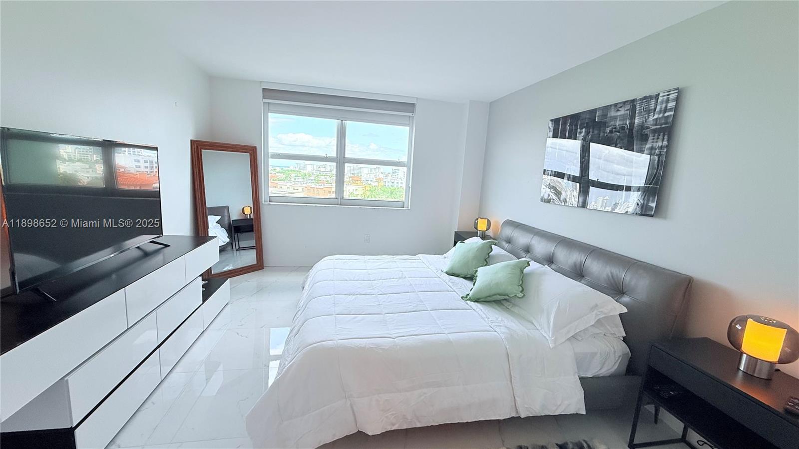 90 Alton Road, Unit 909 Miami Beach, FL 33139 - Photo 7 of 37 a bedroom with a bed and wooden floor