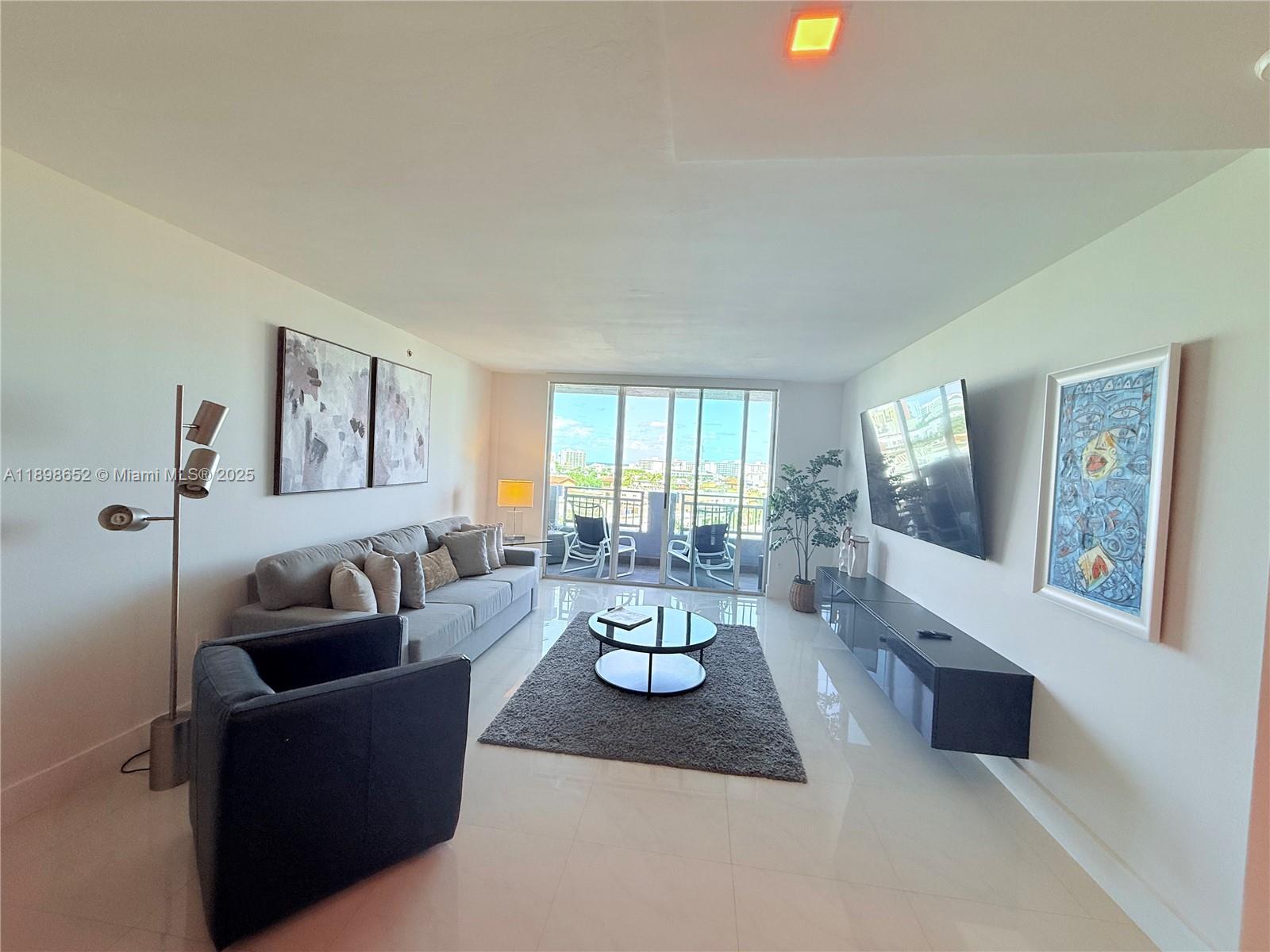 90 Alton Road, Unit 909 Miami Beach, FL 33139 - Photo 8 of 37 a living room with furniture and large windows