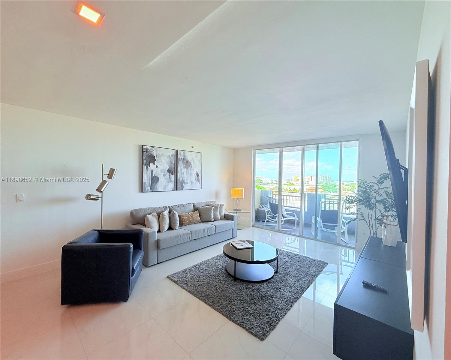 90 Alton Road, Unit 909 Miami Beach, FL 33139 - Photo 9 of 37 a living room with furniture and a large window
