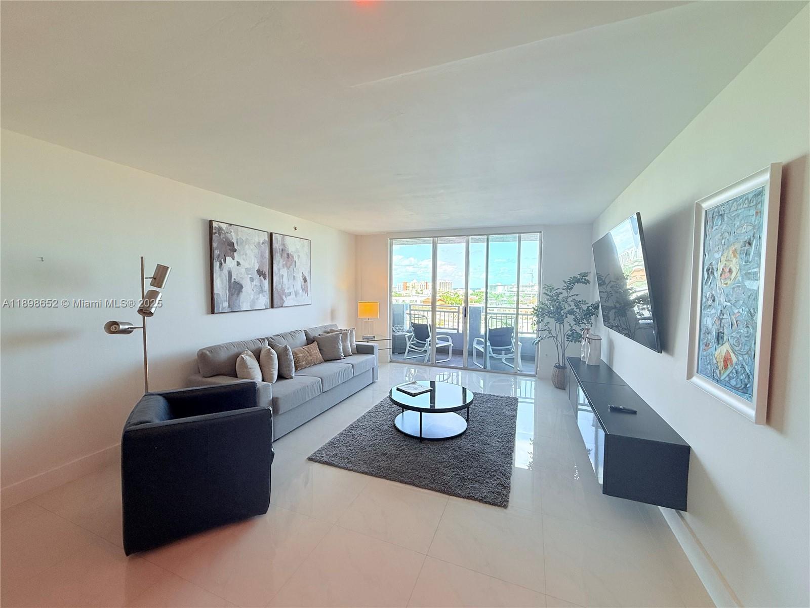 90 Alton Road, Unit 909 Miami Beach, FL 33139 - Photo 10 of 37 a living room with furniture and a large window