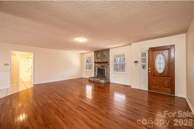 a view of empty room with wooden floor and window
