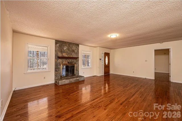 a view of a livingroom with wooden floor and a fireplace