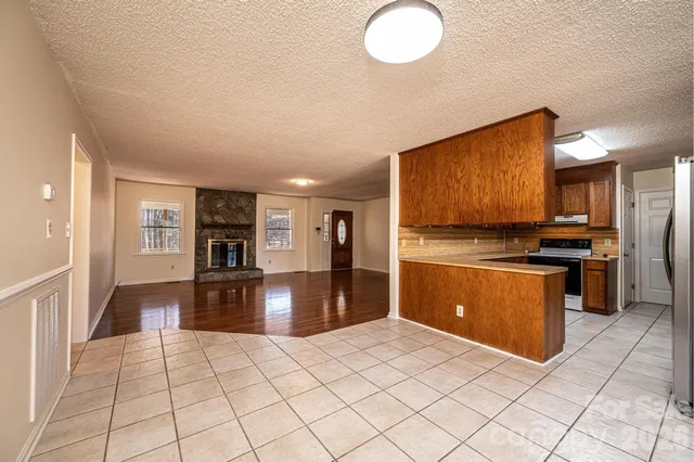 a kitchen with stainless steel appliances granite countertop a refrigerator and a stove top oven