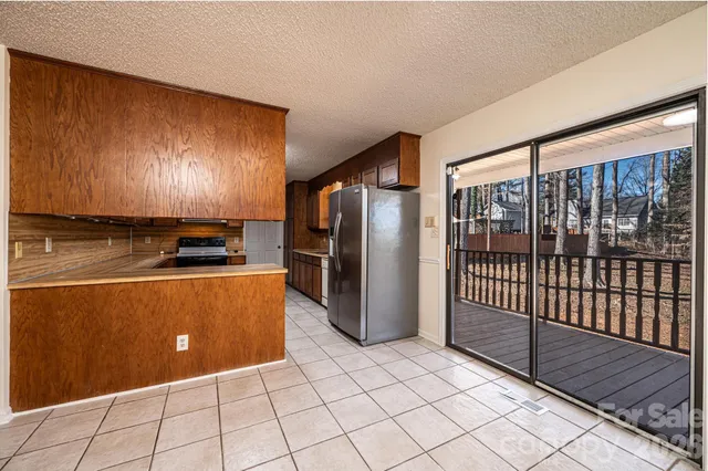 a view of kitchen with stainless steel appliances granite countertop a refrigerator and a stove