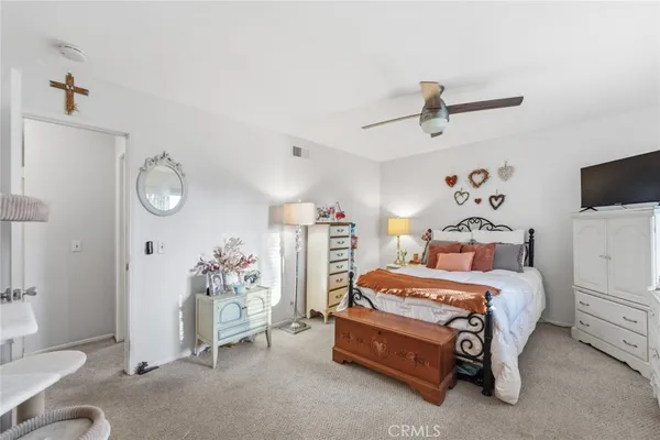 a bedroom with a bed and a flat tv screen on the dresser