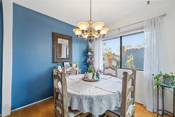 a dining room with furniture potted plants and wooden floor