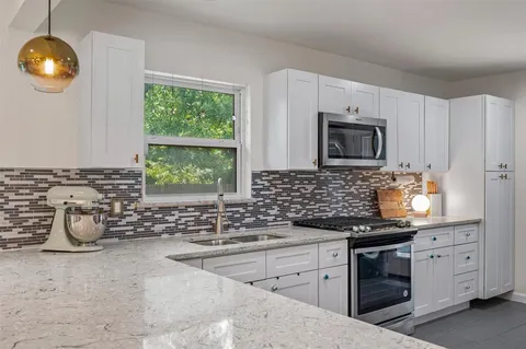 a kitchen with stainless steel appliances a sink stove and microwave