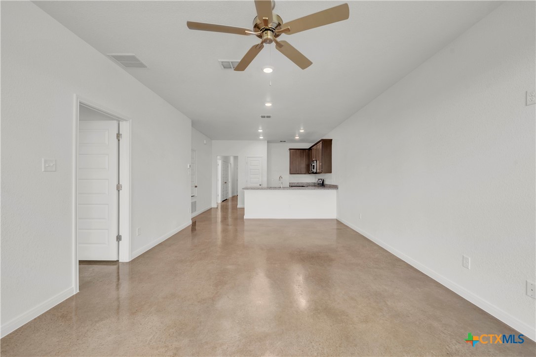 2906 Quail Rdg Lane Temple, TX 76501 - Photo 7 of 17 an empty room with chandelier fan and kitchen view