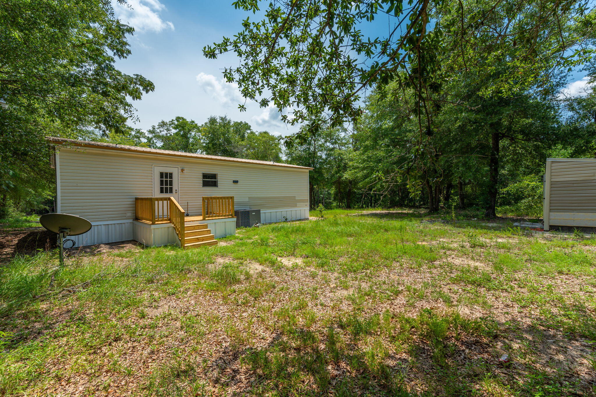 4231 Painter Branch Road Crestview, FL 32539 - Photo 13 of 39 a backyard of a house with barbeque oven and plants