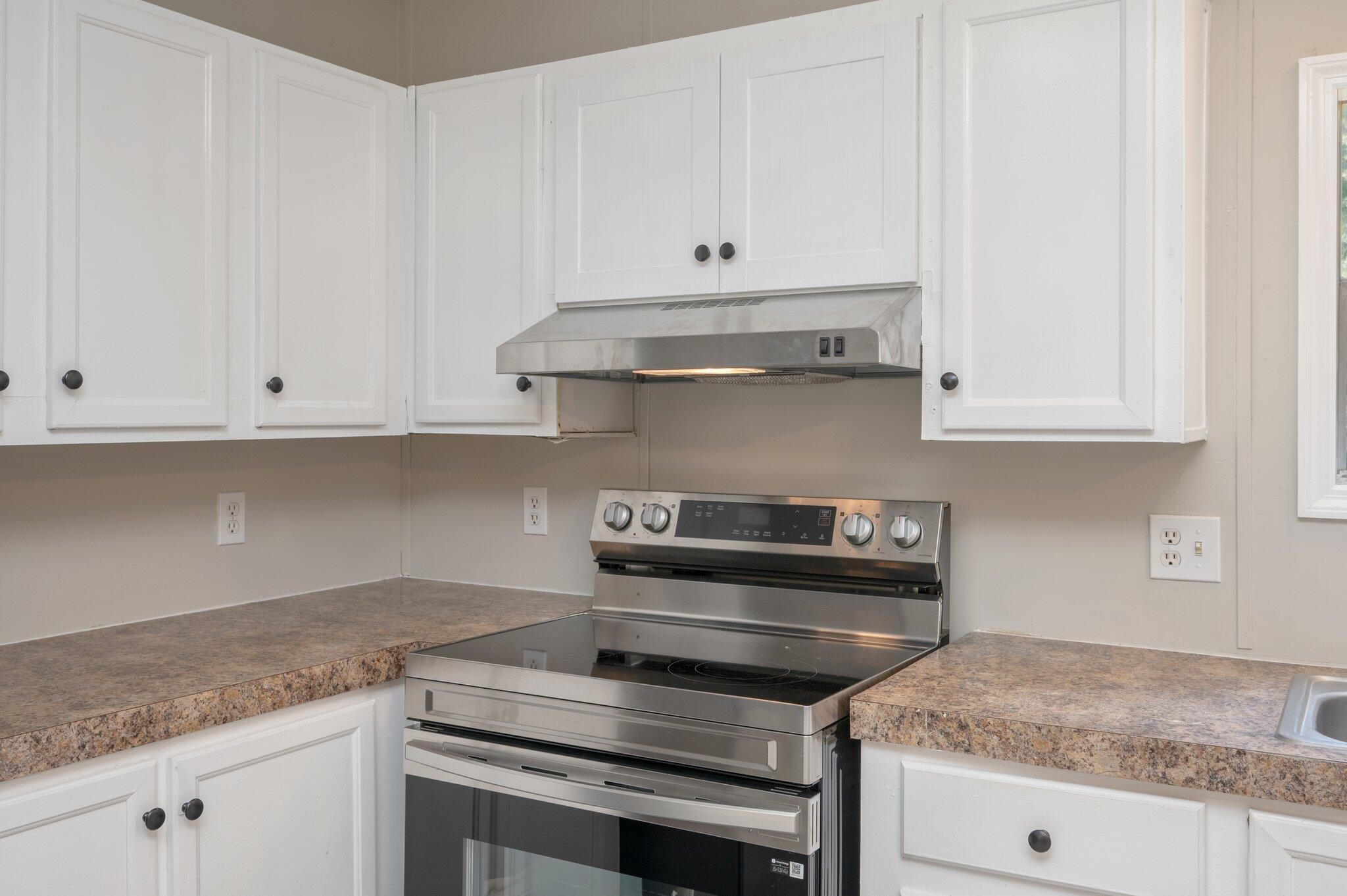 4231 Painter Branch Road Crestview, FL 32539 - Photo 23 of 39 a kitchen with granite countertop white cabinets and a stove