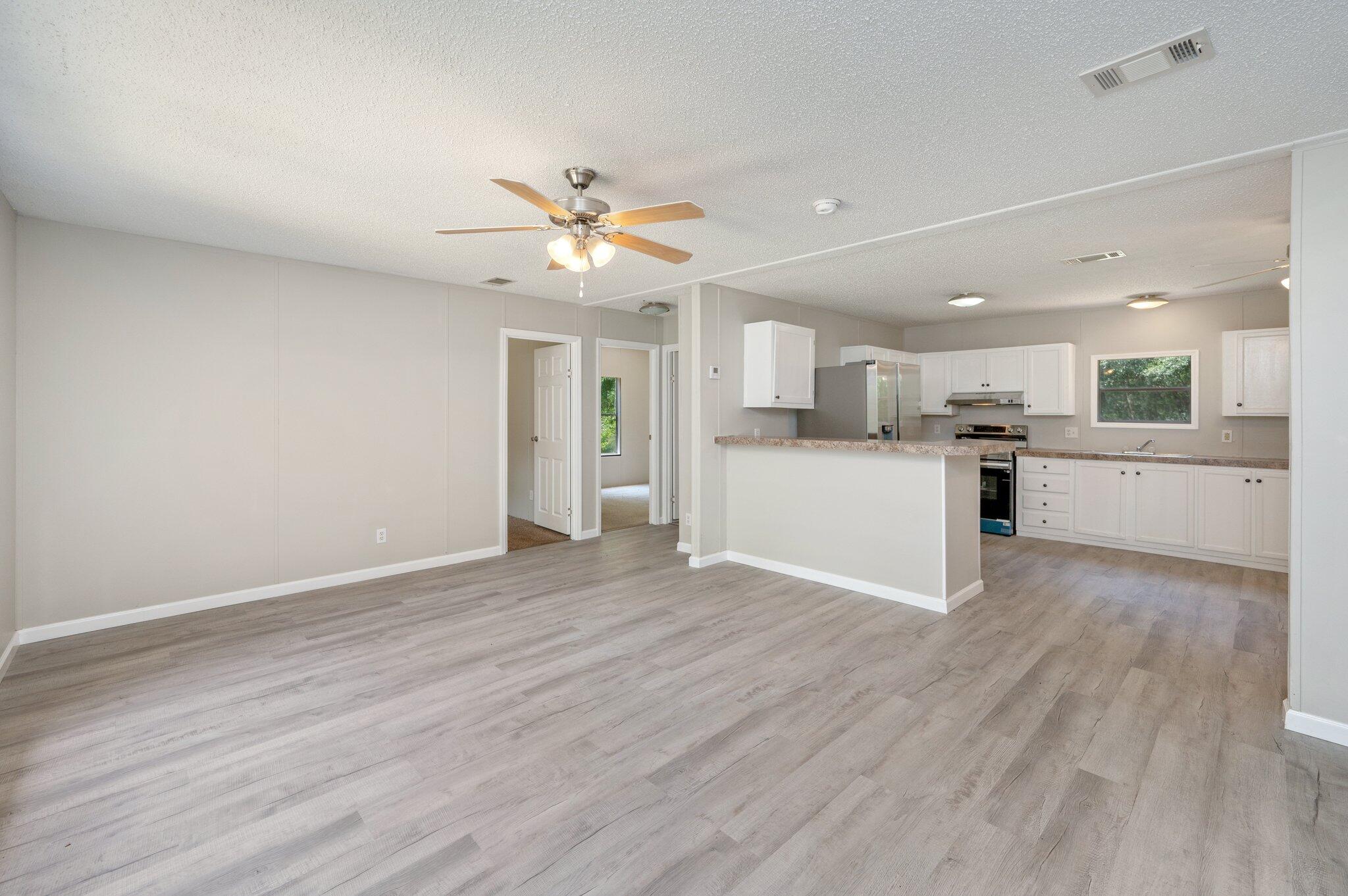 4231 Painter Branch Road Crestview, FL 32539 - Photo 3 of 39 a view of a kitchen with a dishwasher a kitchen island hardwood floor and a sink