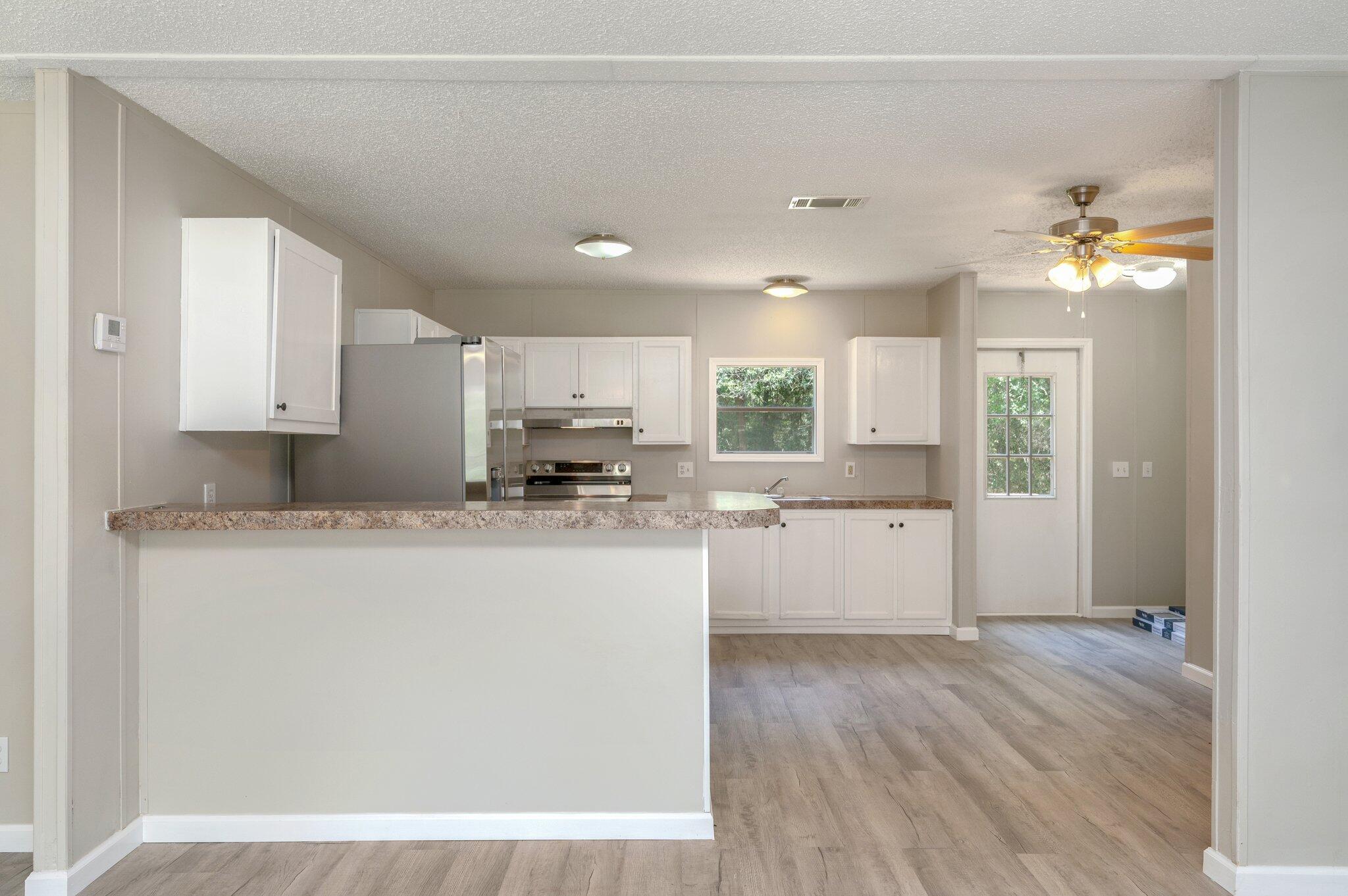 4231 Painter Branch Road Crestview, FL 32539 - Photo 4 of 39 a kitchen with cabinets a sink and wooden floor