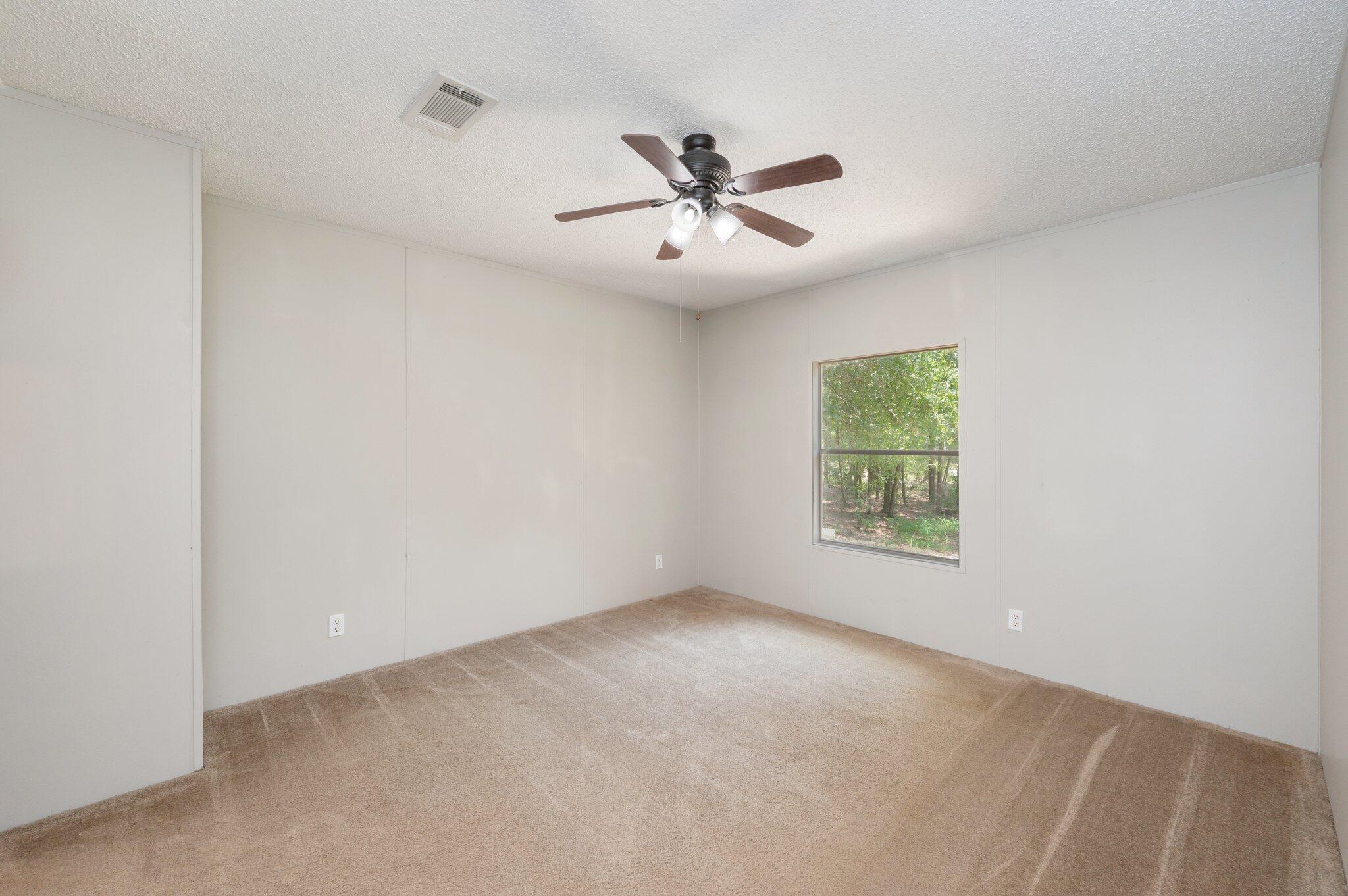 4231 Painter Branch Road Crestview, FL 32539 - Photo 7 of 39 an empty room with a window and a ceiling fan