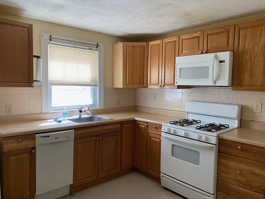 a kitchen with cabinets appliances a sink and a window