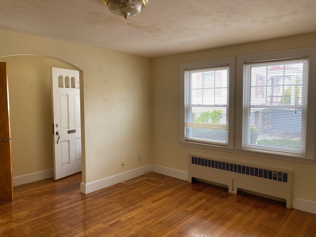 460 A Highland Avenue, Unit 2 Malden, MA 02148 - Photo 2 of 7 an empty room with wooden floor and windows