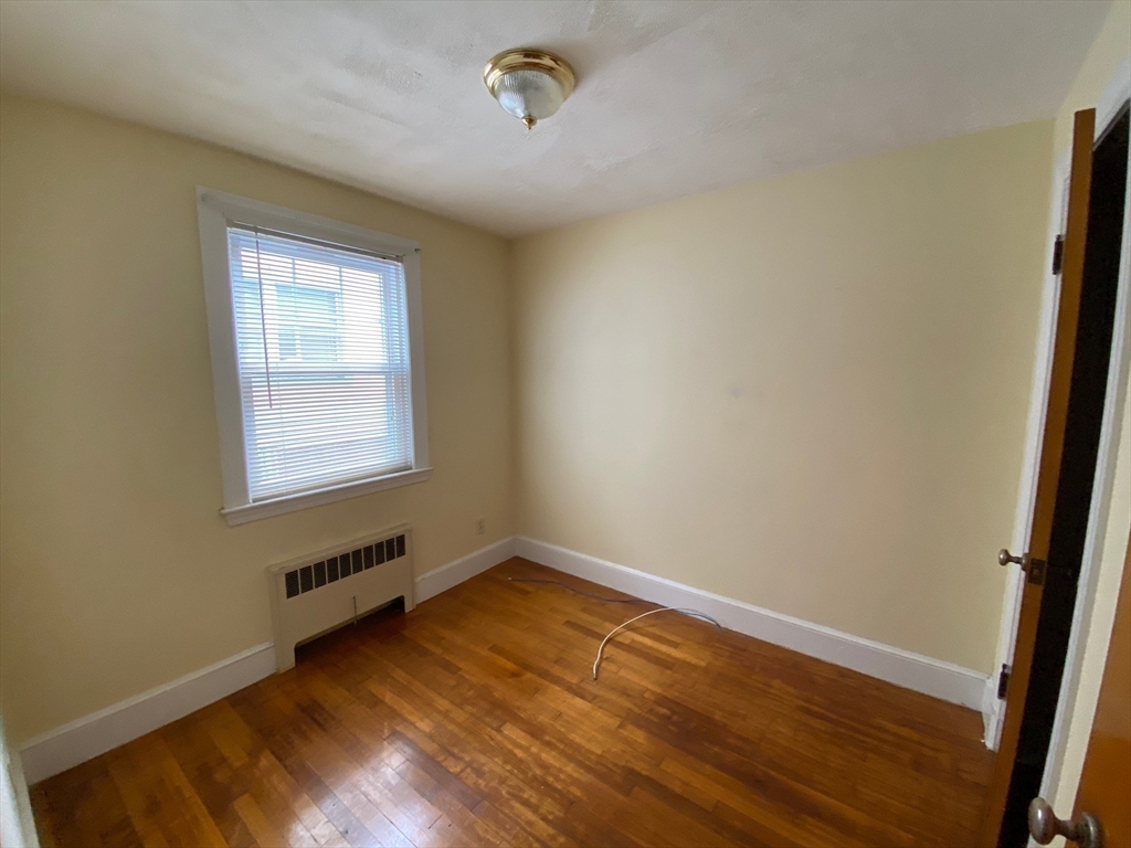 460 A Highland Avenue, Unit 2 Malden, MA 02148 - Photo 7 of 7 a view of an empty room with wooden floor and a window
