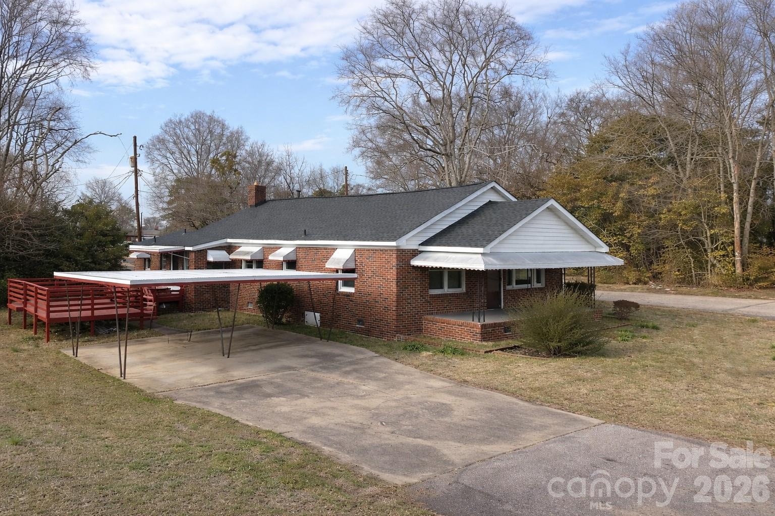 a view of a house with a cars park side of a road