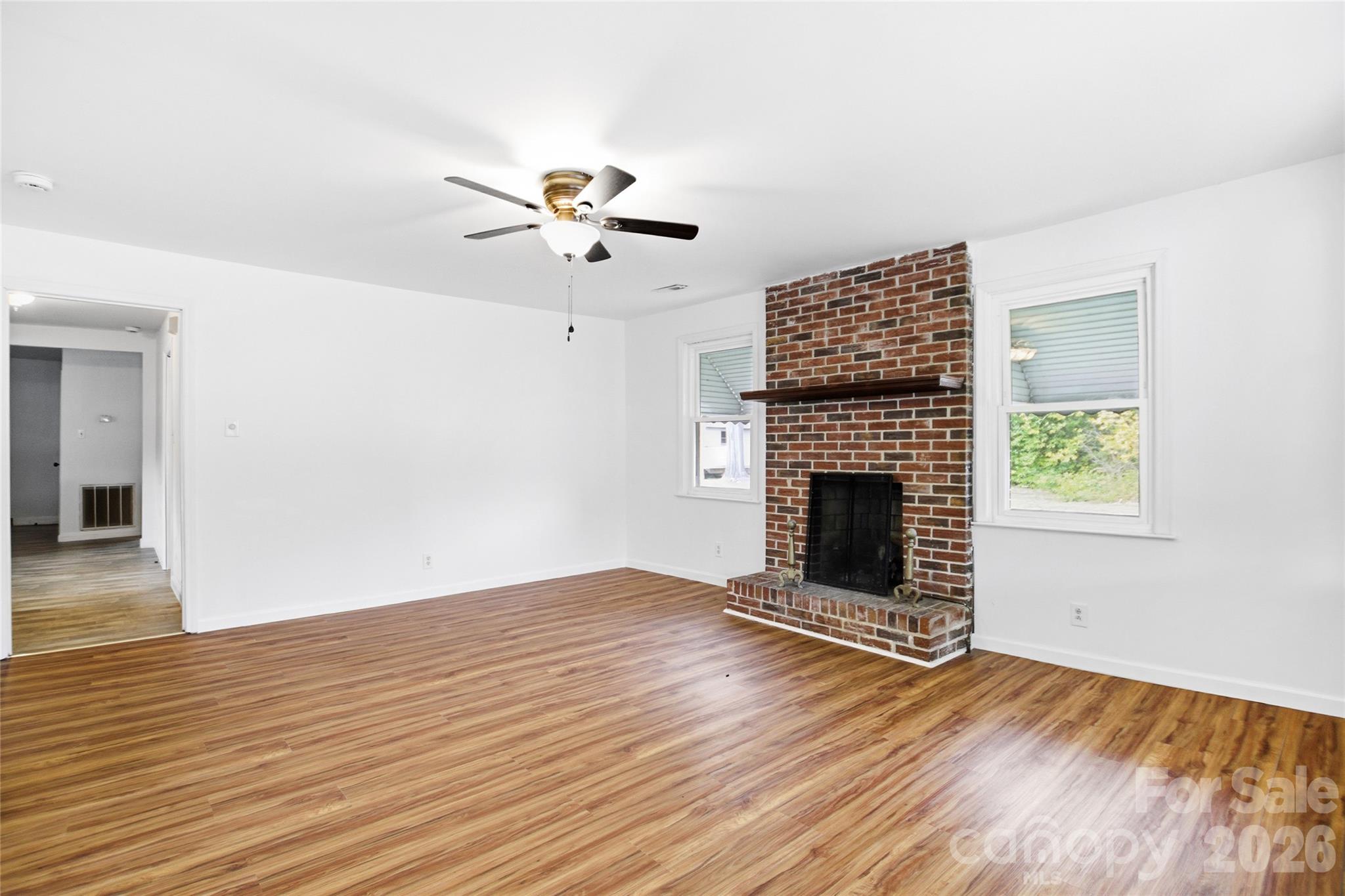 213 Jewel Street Chester, SC 29706 - Photo 2 of 21 a view of an empty room with wooden floor fireplace and a window