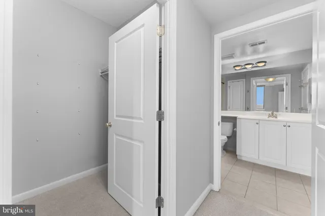 a bathroom with white cabinets
