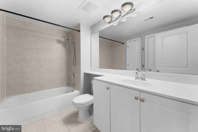a bathroom with a granite countertop sink a toilet and shower